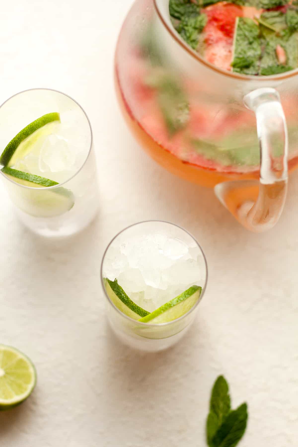 Overhead view of two glasses filled with ice and some lime slices.