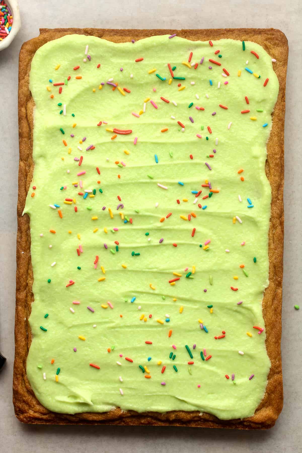 A rectangle blondie with buttercream and sprinkles - before slicing.