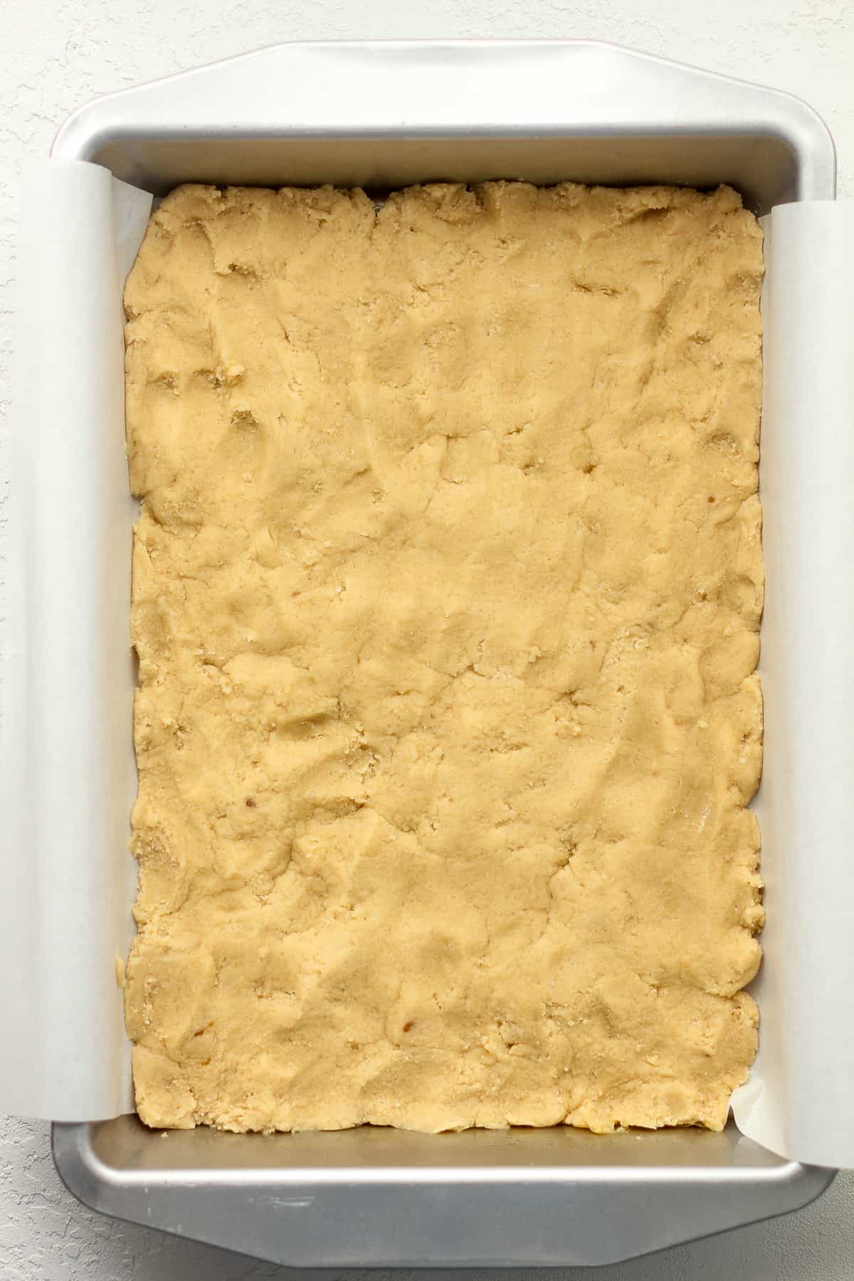 A pan of the blondie dough after pressing into the pan.