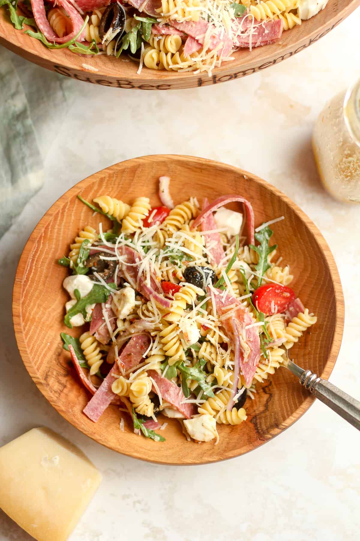 A serving bowl of the zesty pasta salad with a fork.