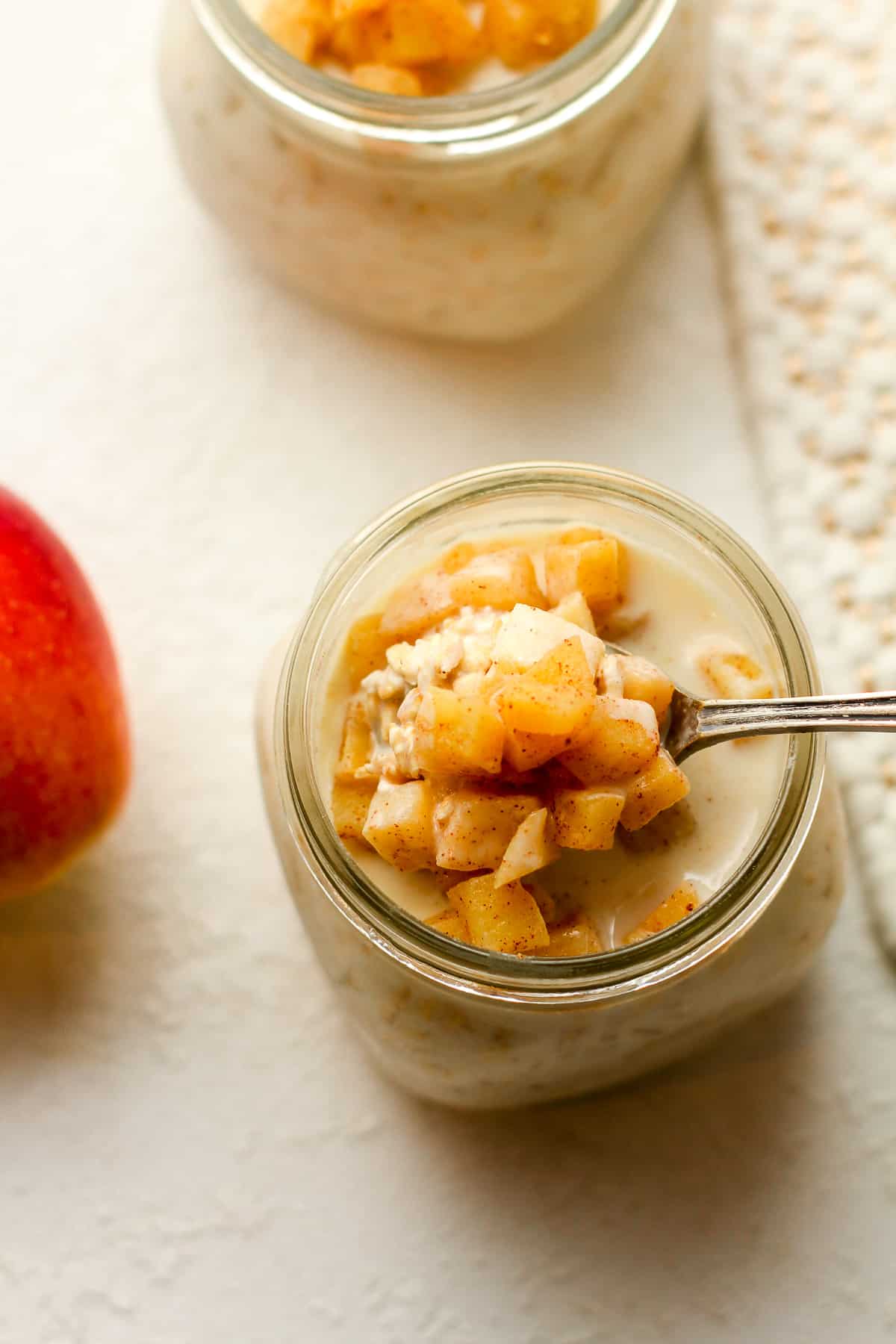 Overhead shot of a jar of apple cinnamon overnight oats with a spoonful on top.