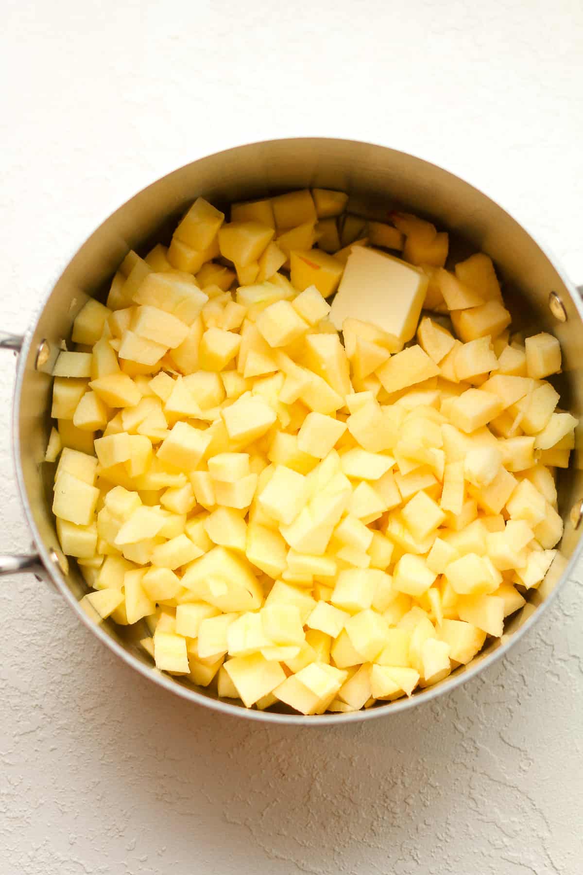 The diced apples in a pan with a tablespoon of butter.