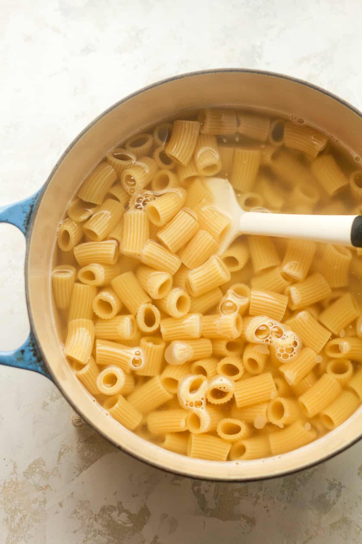 A pot of boiled rigatoni pasta.