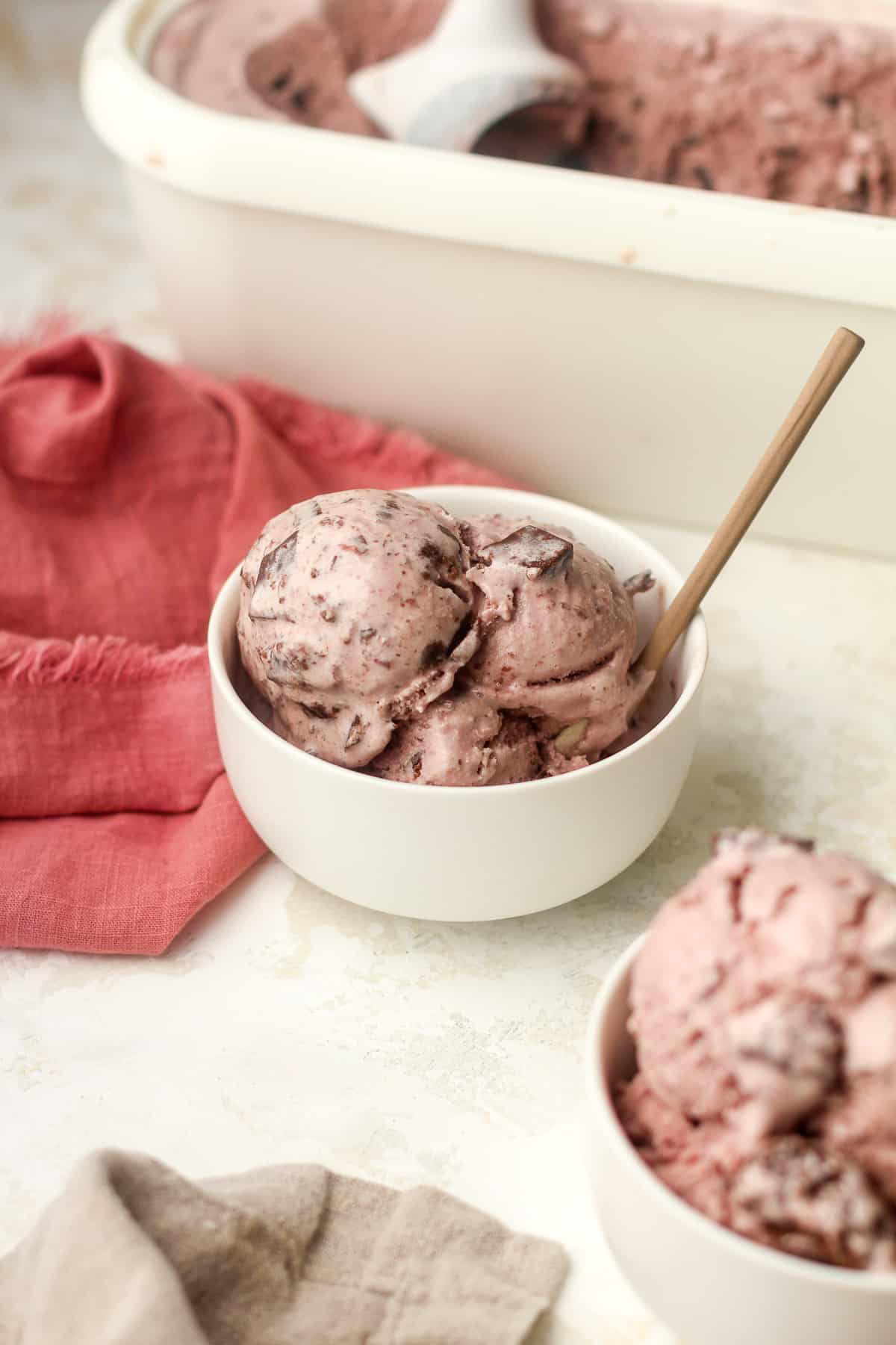 Side view of two bowls of cherry ice cream with chocolate chunks.