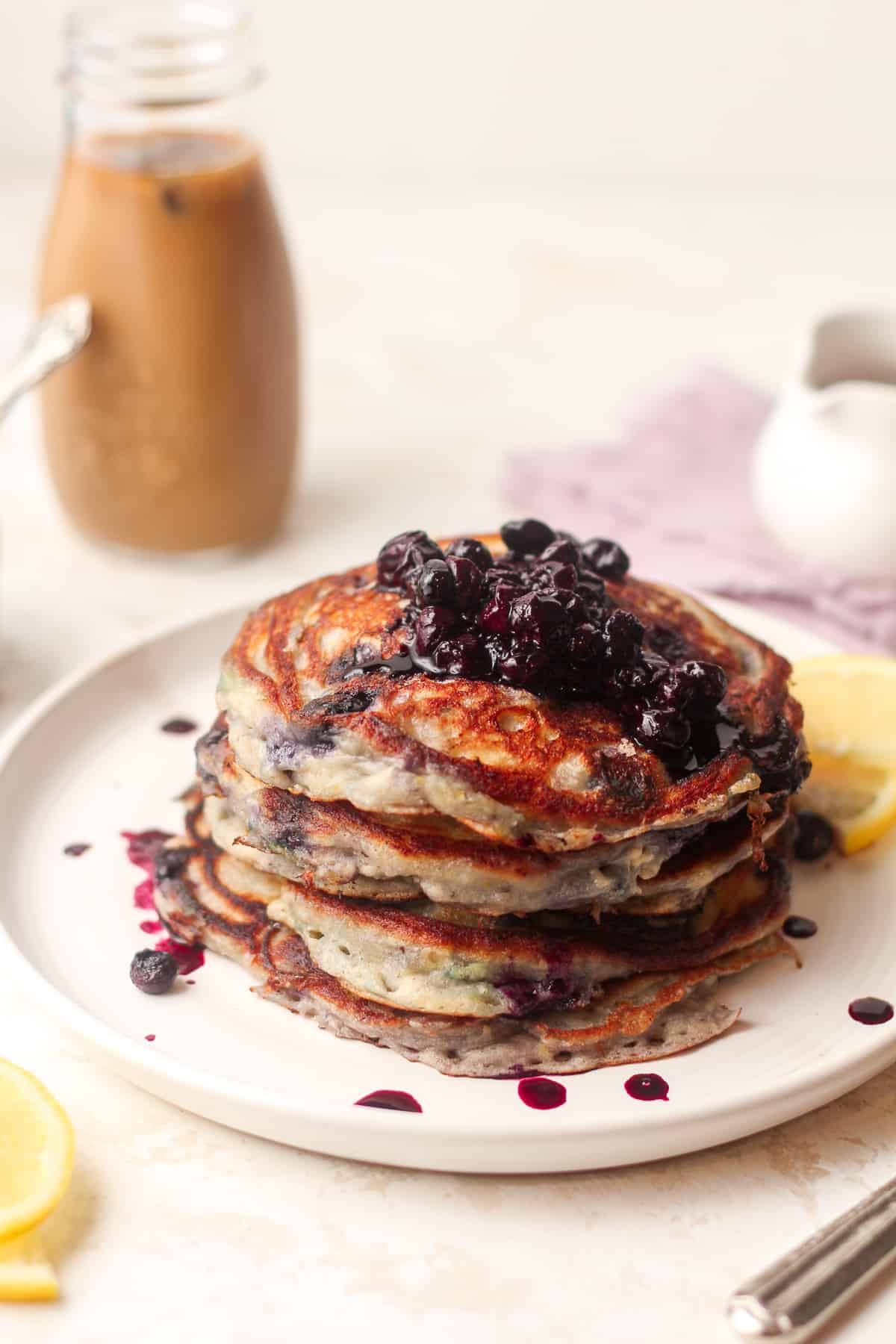 Side view of four stacked fluffy blueberry lemon pancakes.