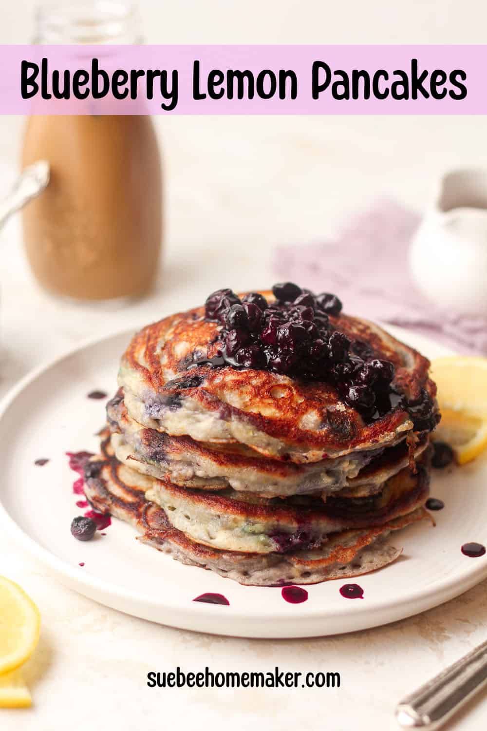 A plate of blueberry lemon pancakes with some blueberry compote on top.