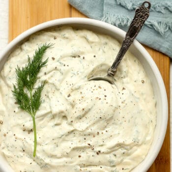 A closeup on a bowl of dill pickle ranch dressing.