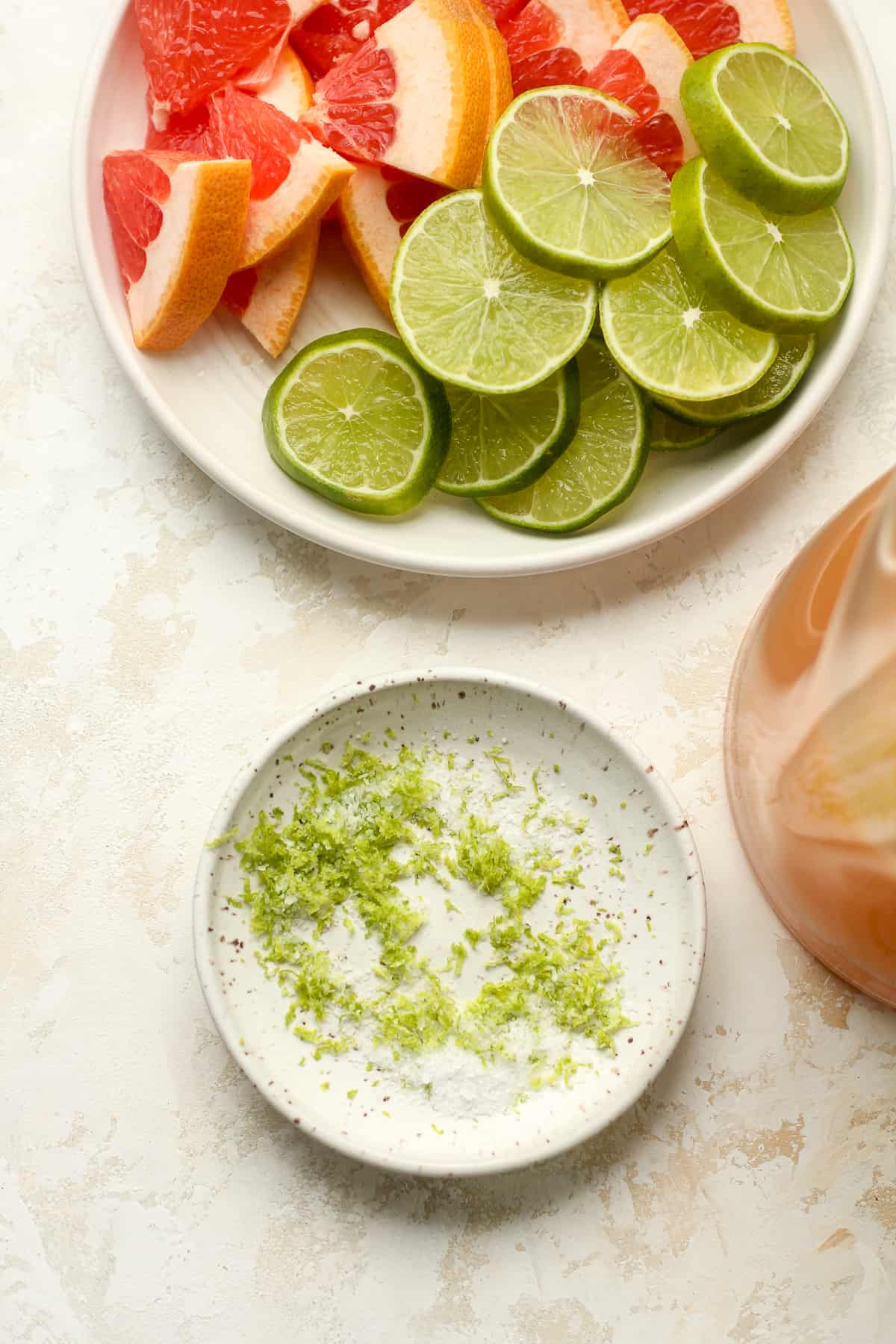 A plate of the lime garnish with a plate of lime and grapefruit wedges.