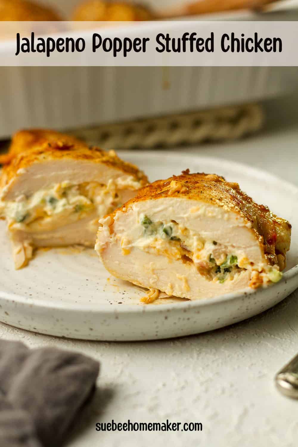A plate with a halved stuffed chicken breast showing the filling inside.