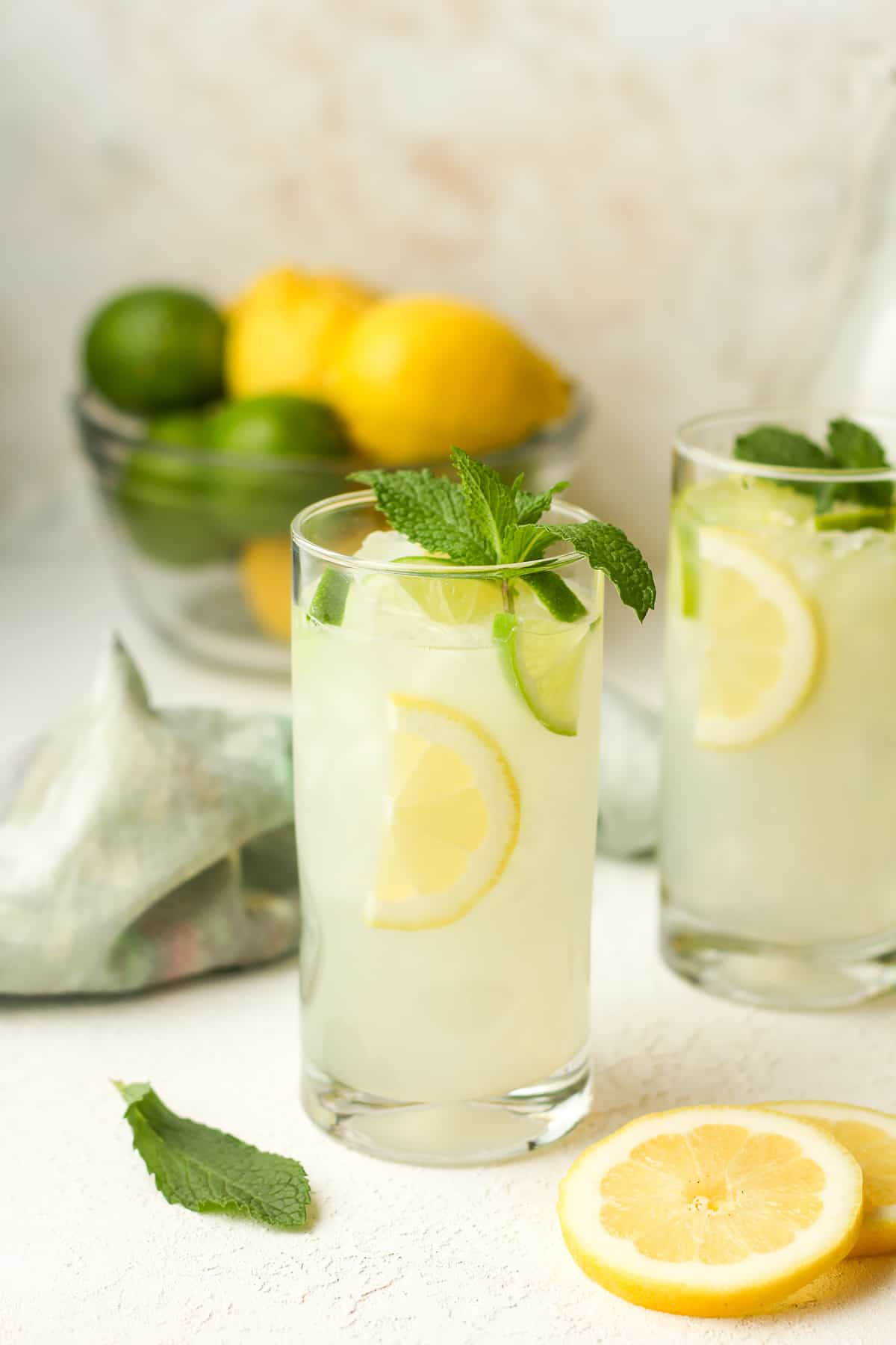 Two tall glasses of lemon mojito cocktails.