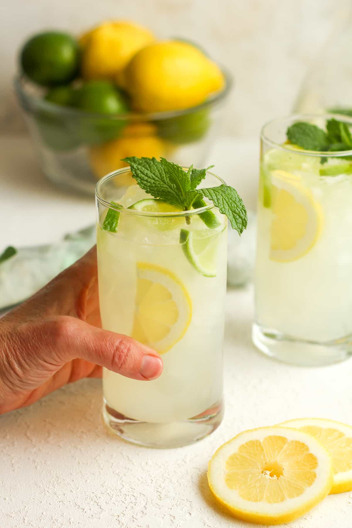 Two tall glasses of lemon-lime mojitos.