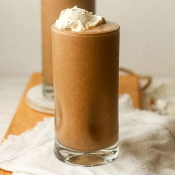 Closeup on a tall coffee smoothie with whipped topping.