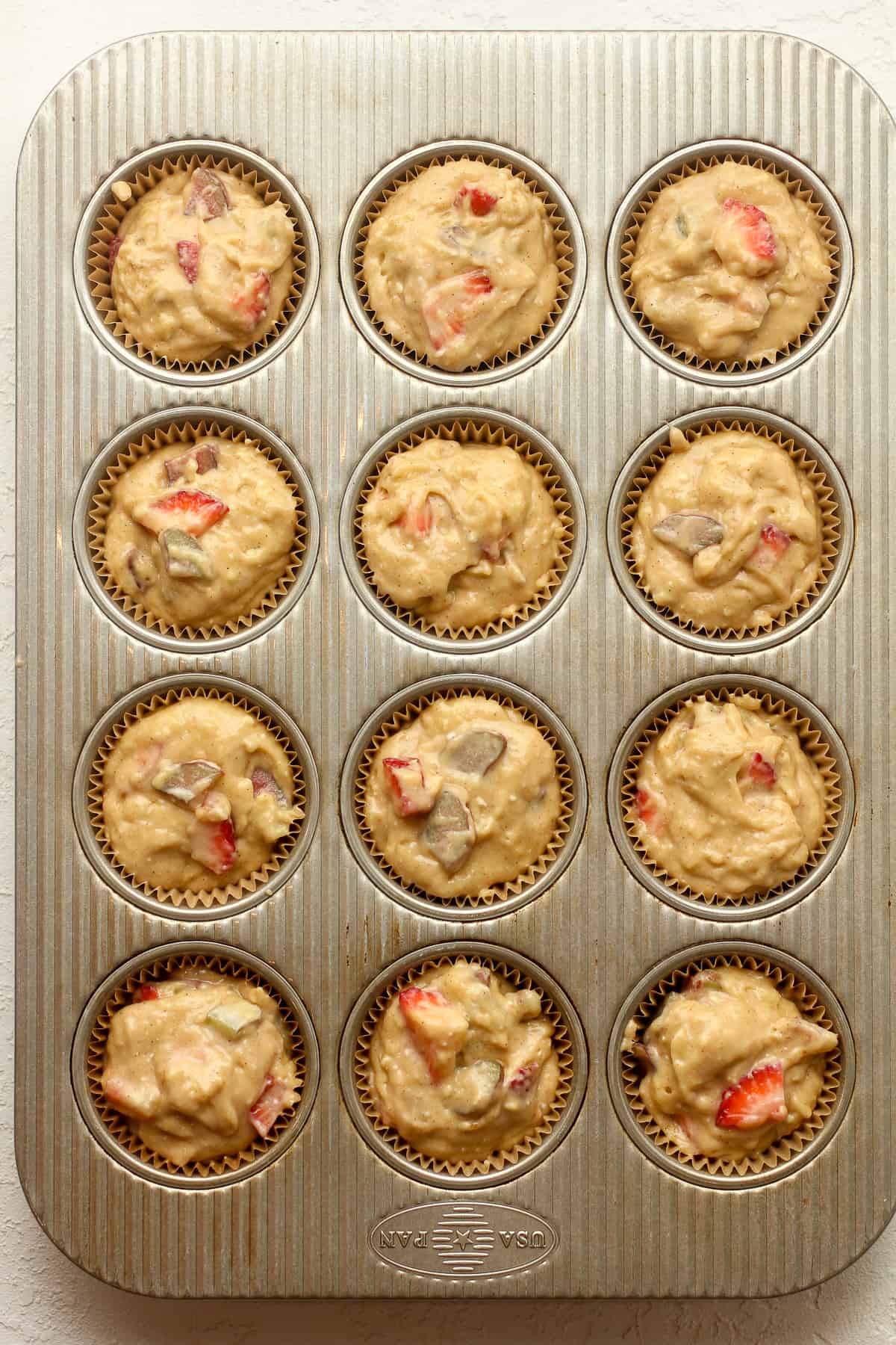 A 12 cup muffin pan with the batter.