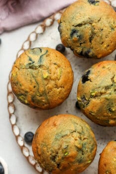 Some blueberry zucchini muffins on a plate.