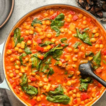A shallow pot of curried chickpeas and spinach.