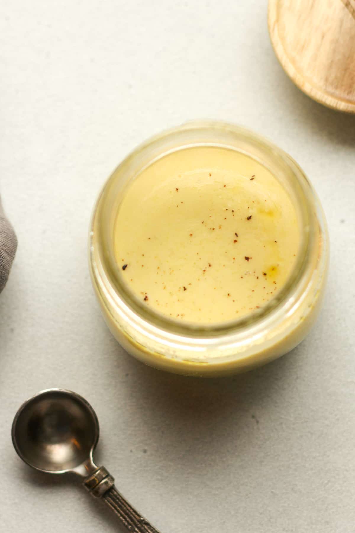 Overhead view of a jar of light honey mustard dressing.
