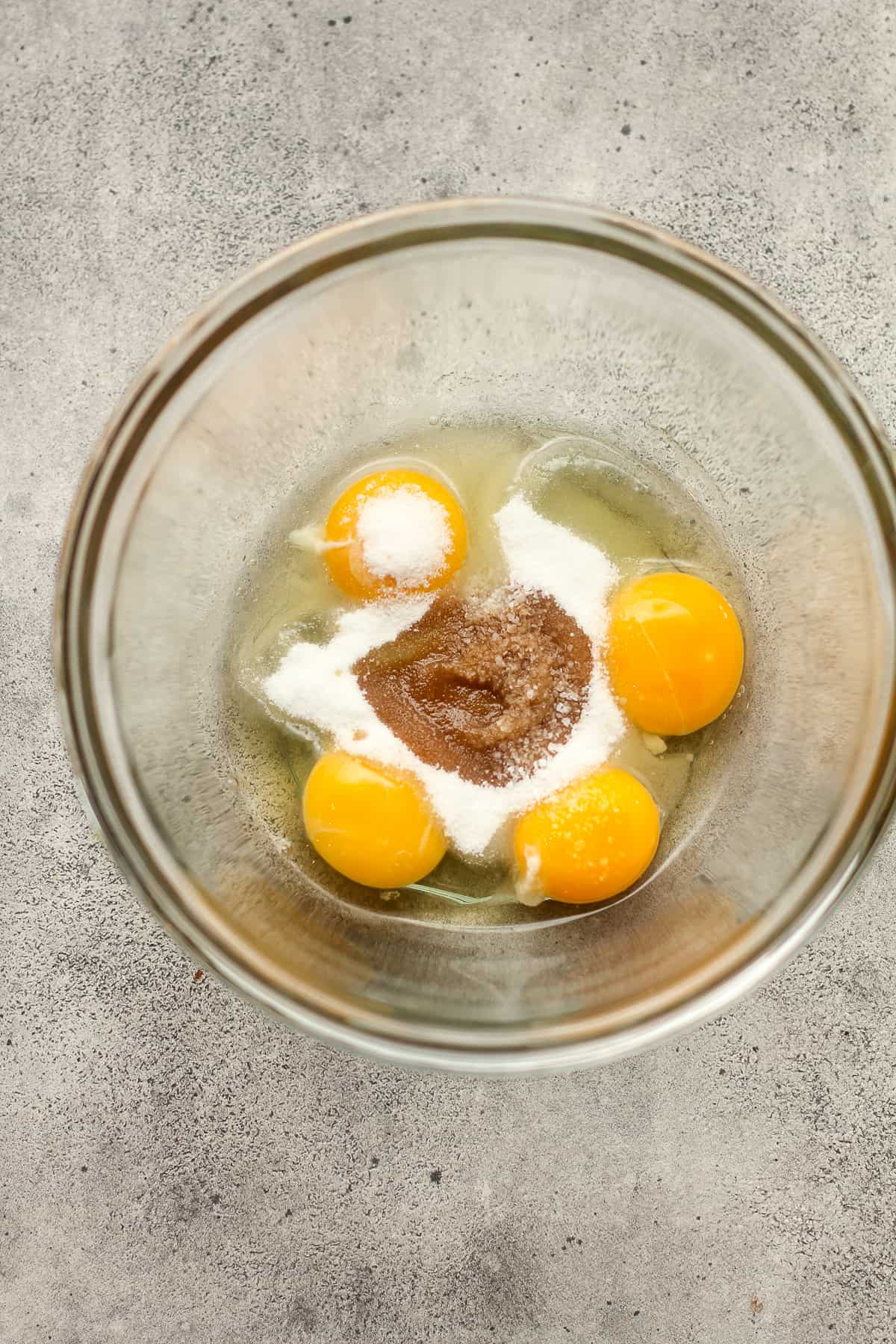 A bowl of the eggs, sugar, salt, and vanilla.