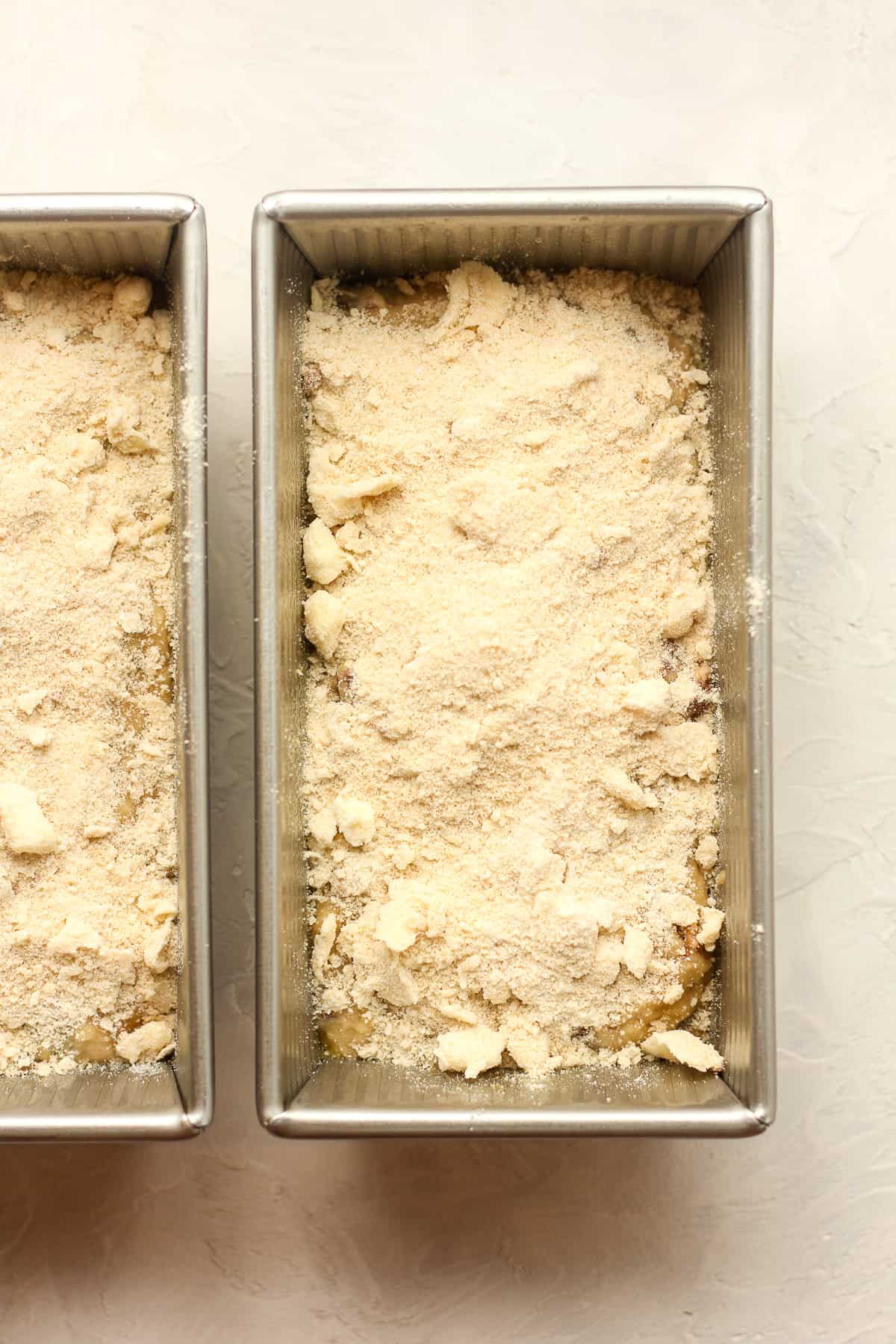 Two pans of prepped rhubab bread with the crumb topping.