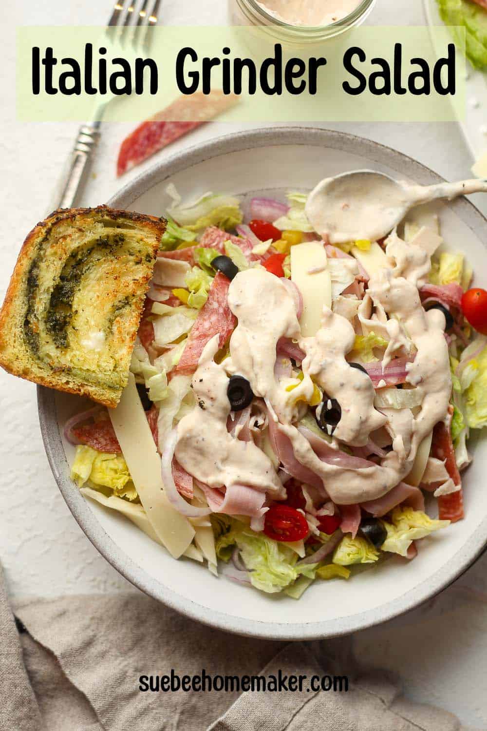 A bowl of Italian grinder salad with creamy dressing drizzled on top.