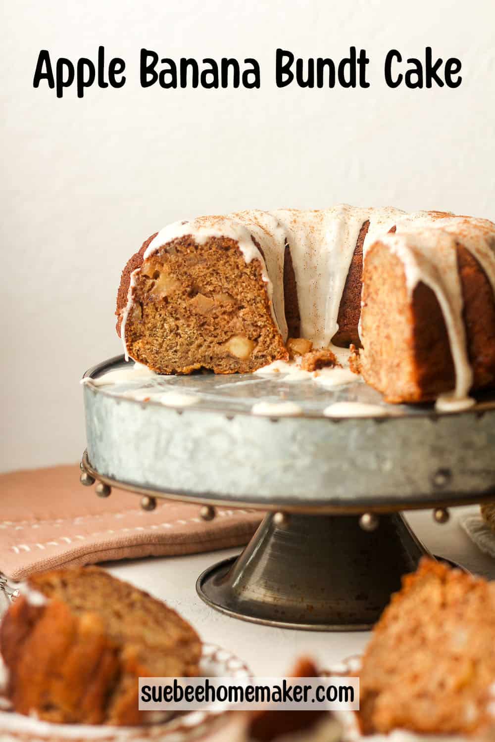A silver cake stand with a partial apple banana bundt cake with cinnamon glaze.