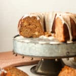 Side view of a partial apple banana bundt cake with a simple frosting.