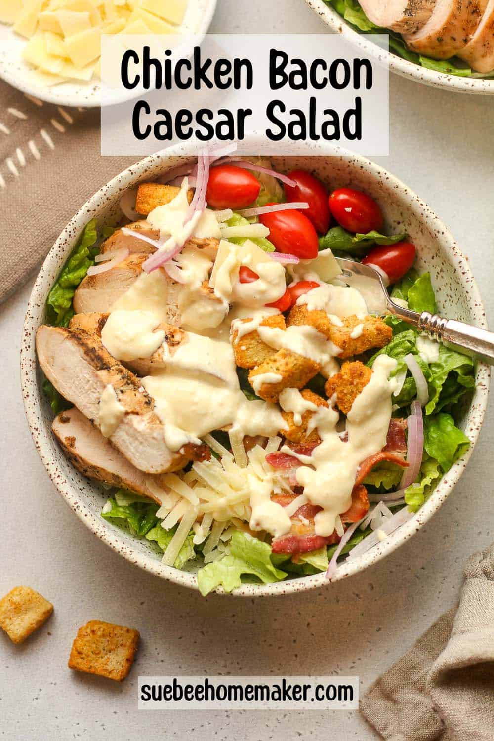 A chicken bacon caesar salad with caesar dressing on top.