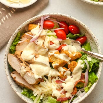 Closeup on a chicken bacon salad with caesar dressing.
