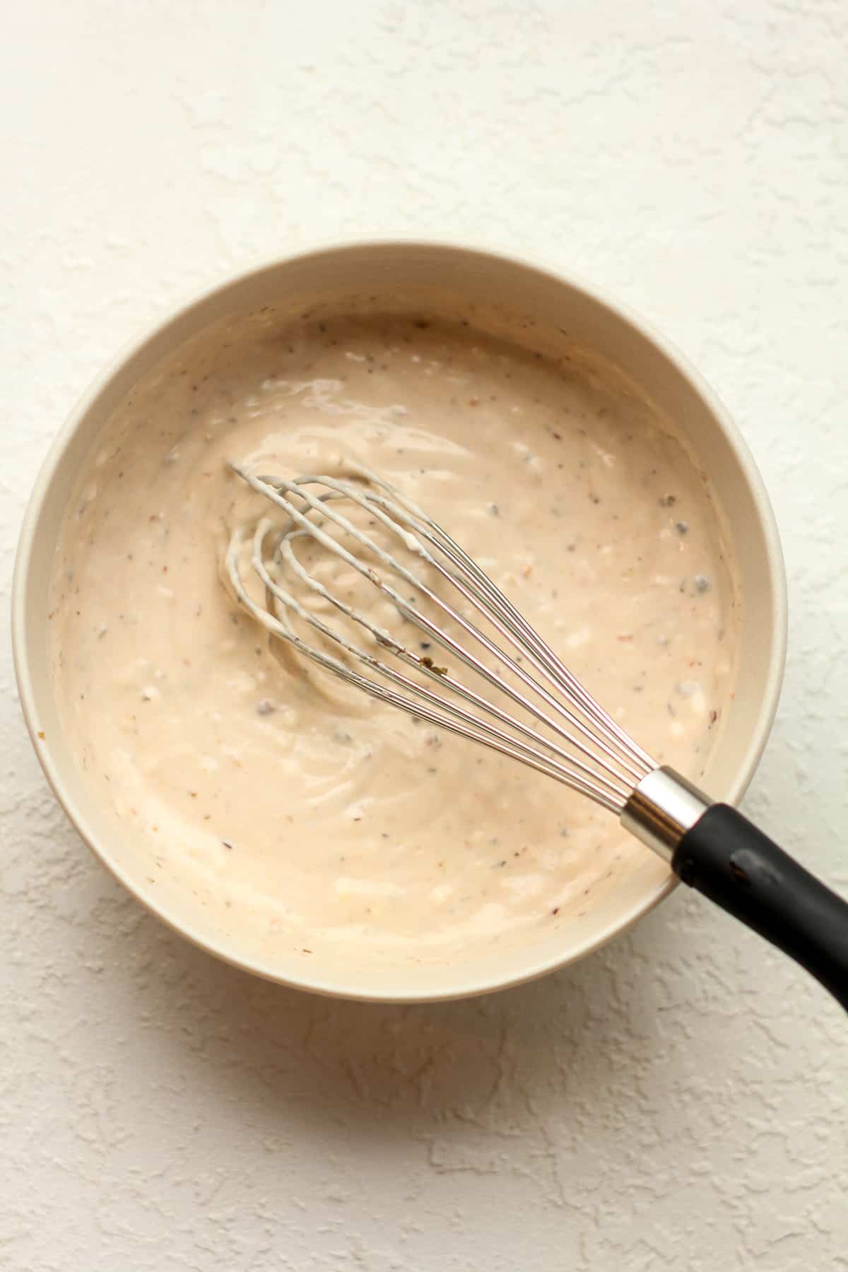 A bowl of the grinder dressing with a whisk.