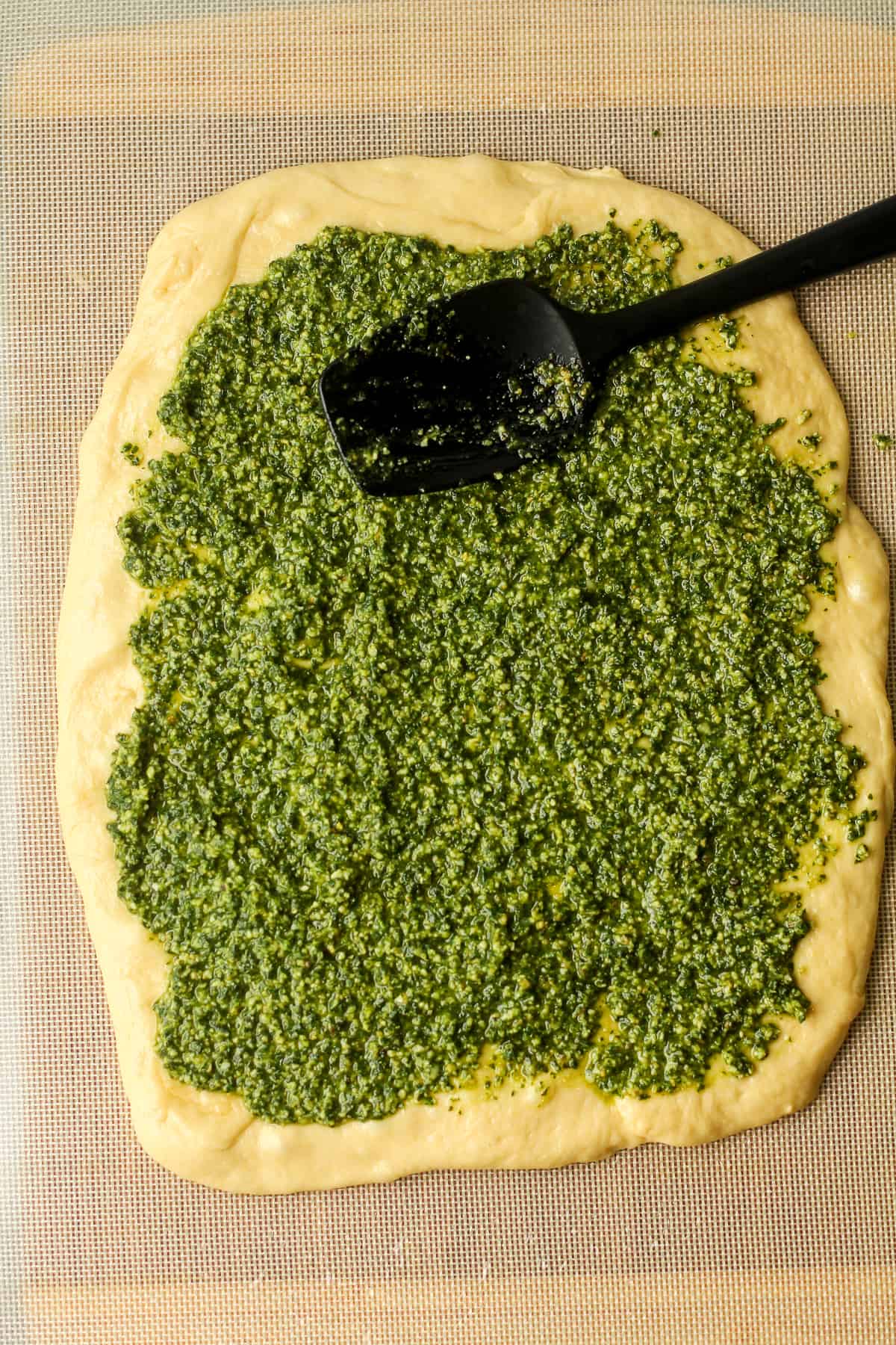 The bread dough with pesto on top.