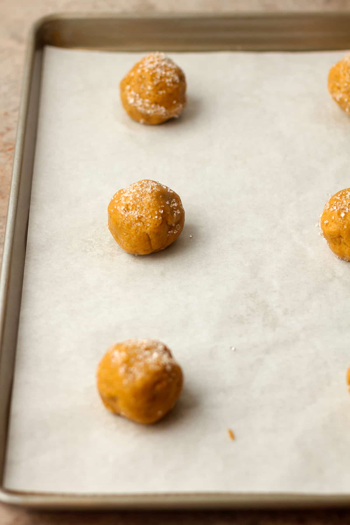 Side view of a pan of cookie balls rolled in sparkling sugar.