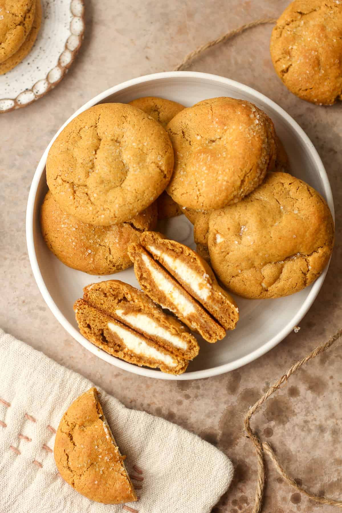 A bowl of pumpkin cookies stuffed with cream cheese.