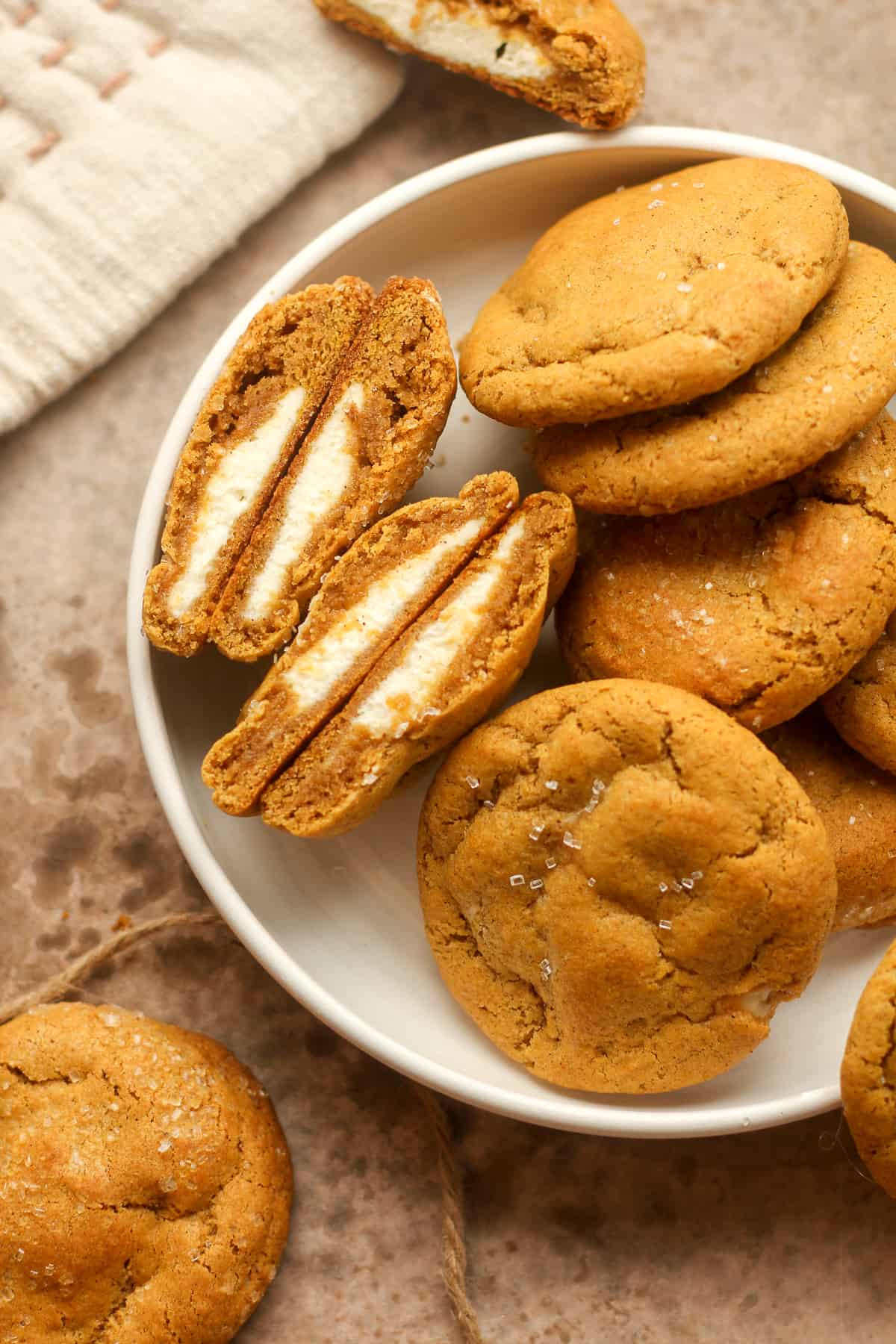 A plate of pumpkin cookies stuffed with cream cheese.