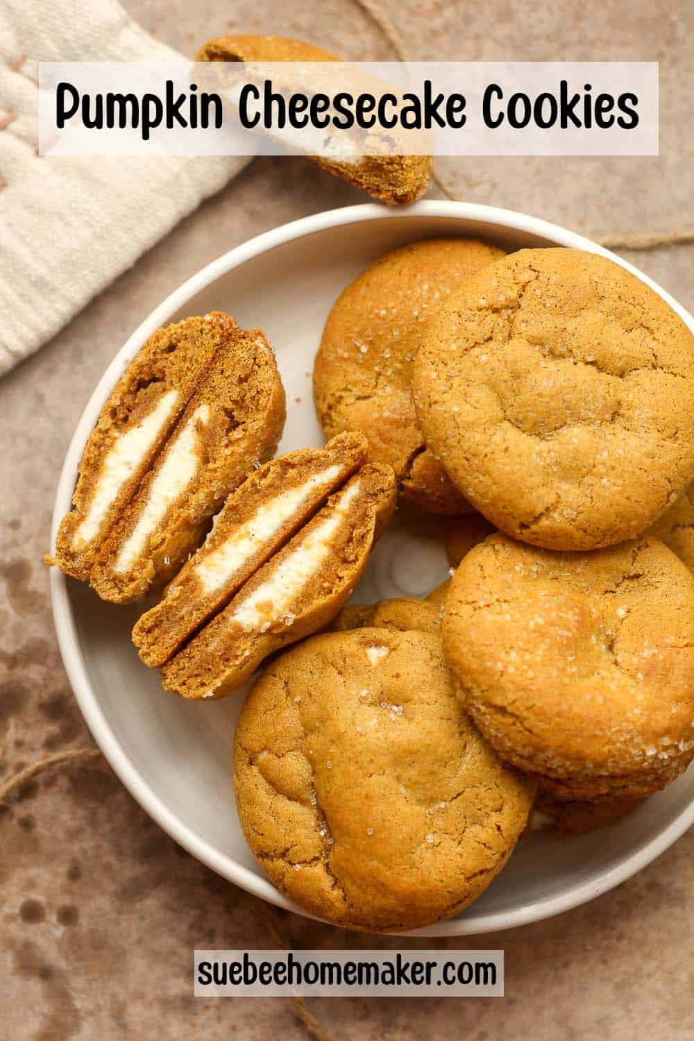 A bowl of pumpkin cheesecake cookies showing the insides of two of them.