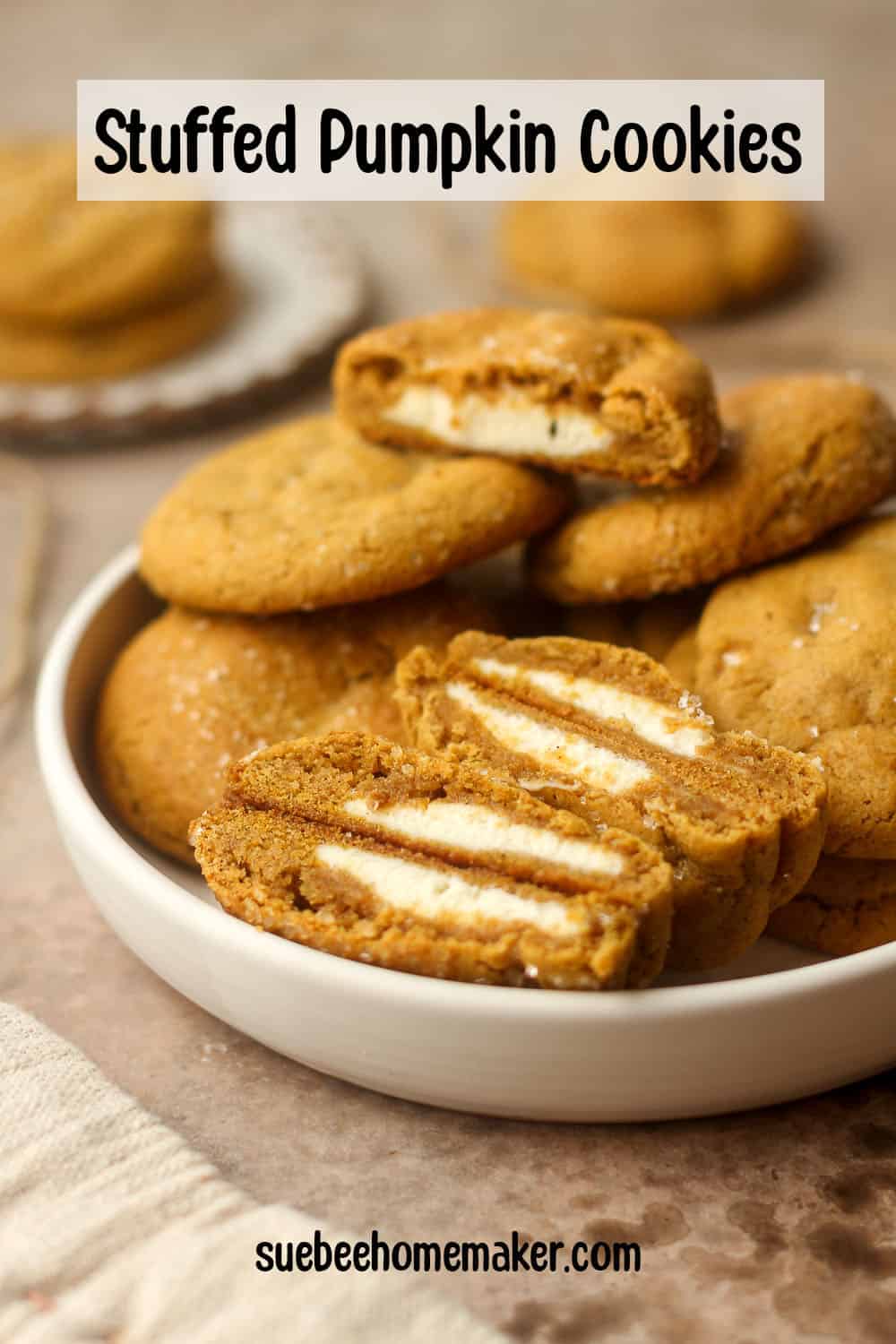 Side view of a bowl of stuffed pumpkin cookies with some cut in half.