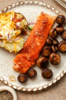 A plate of smoked salmon, sauteed potatoes, and a smoked potato.
