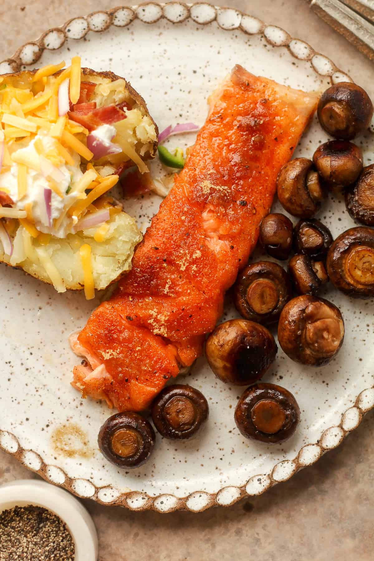 A plate of smoked salmon, sauteed potatoes, and a smoked potato.