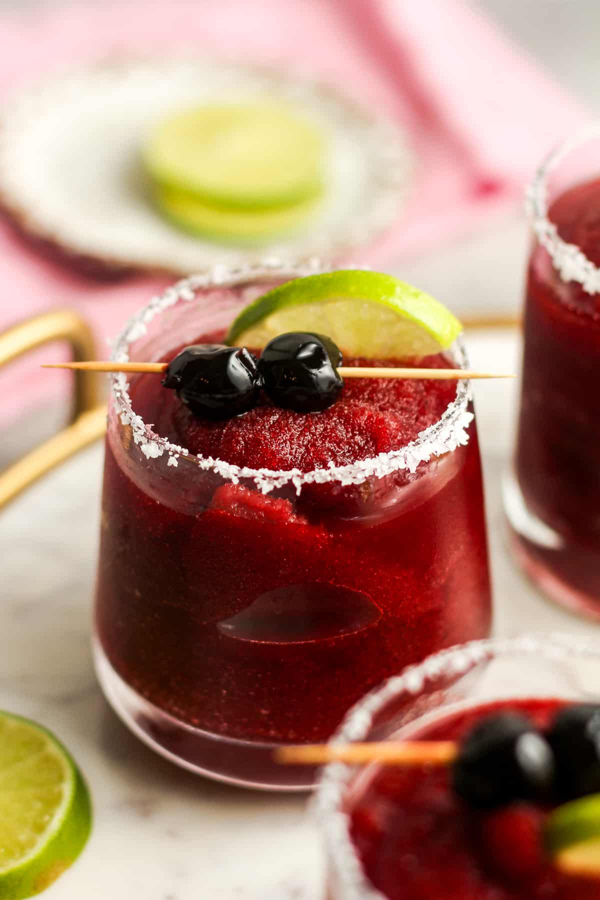 Side view of some cherry margaritas on a tray.