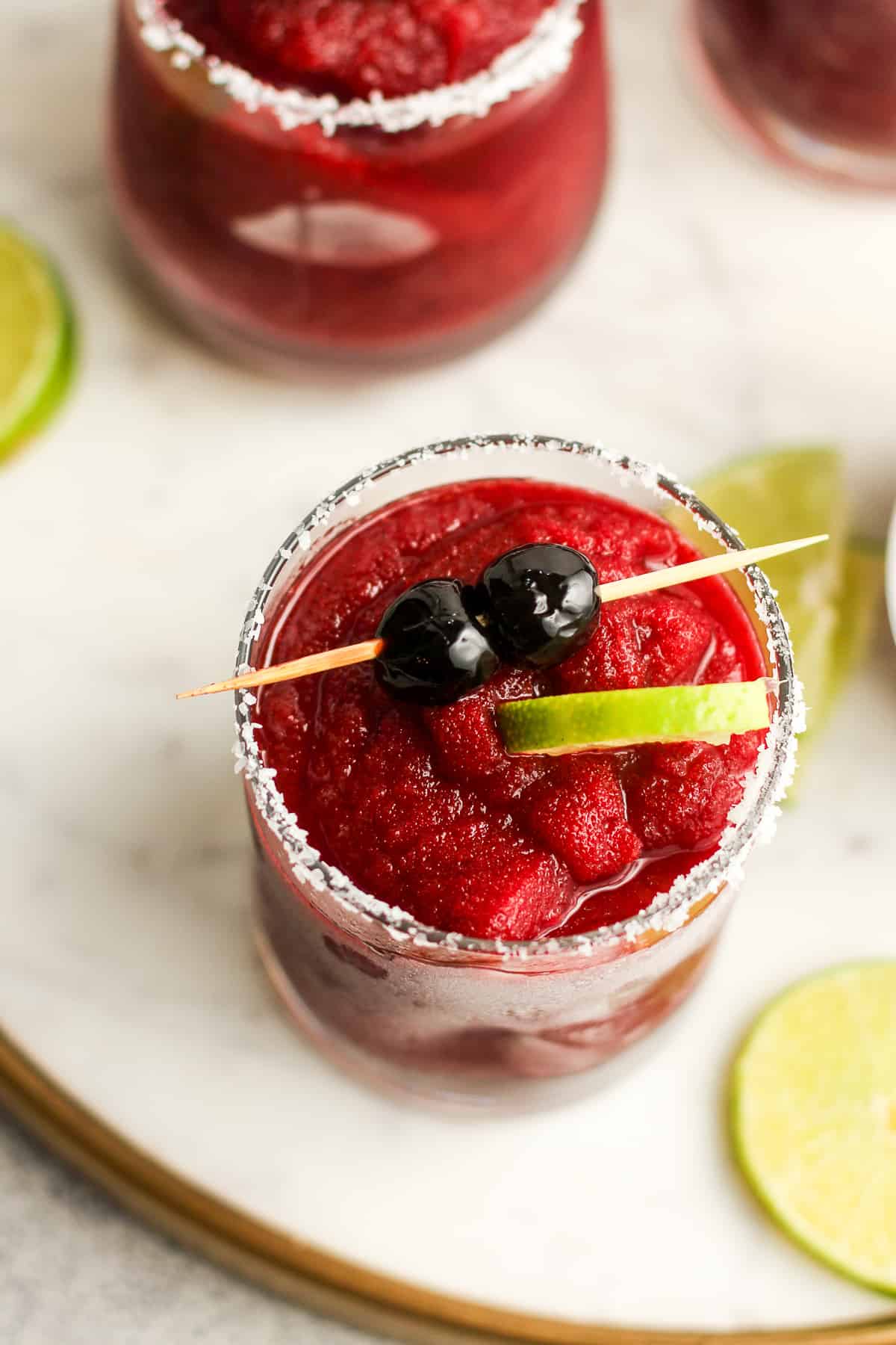 Overhead view of a cherry margarita with a cherry garnish.