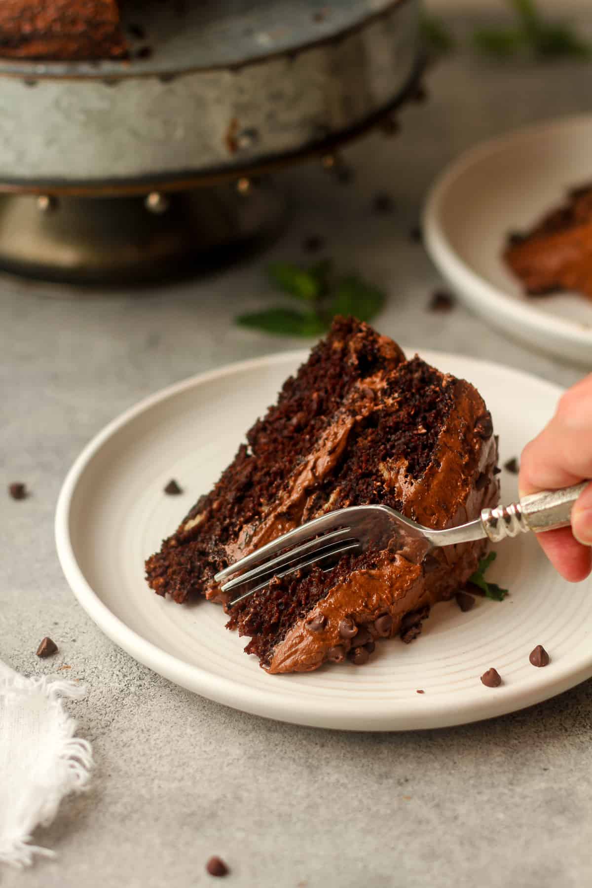 A fork digging into a piece of chocolate cake.