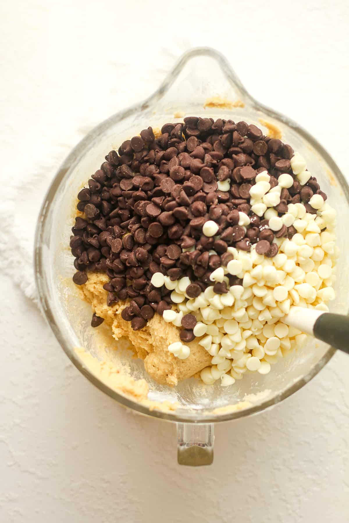 A mixer bowl of the dough after adding semi-sweet chocolate chips and white chocolate chips.