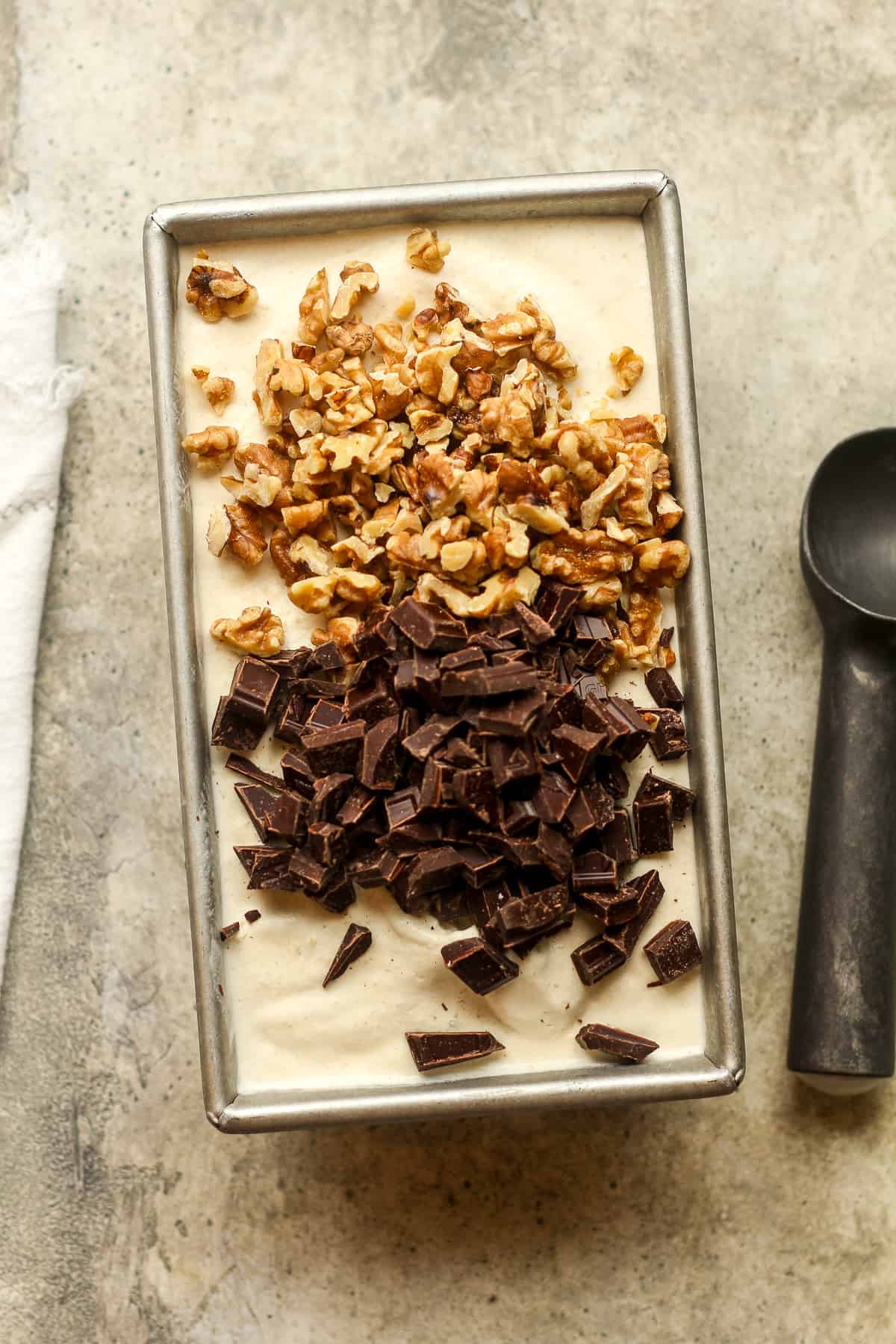 A pan of banana ice cream with walnuts and chocolate on top.