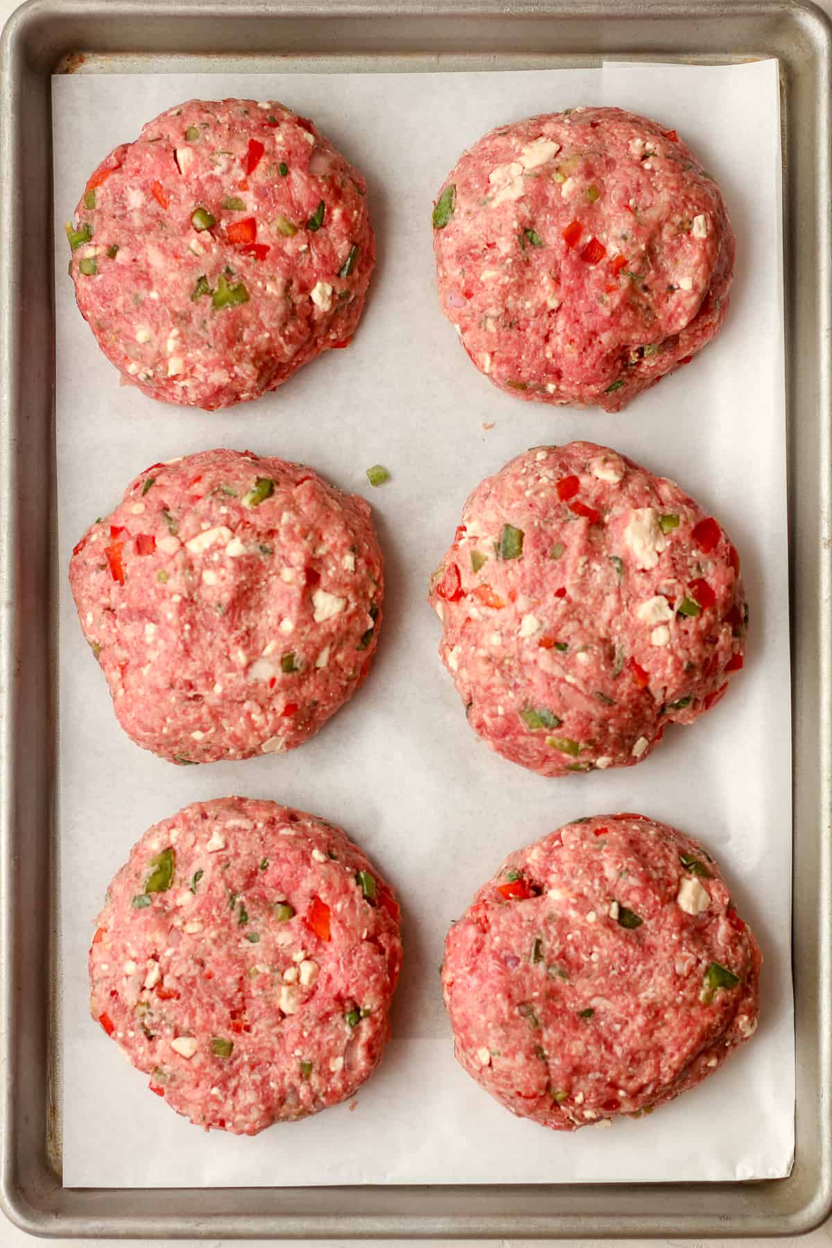 Six burger patties ready to grill.