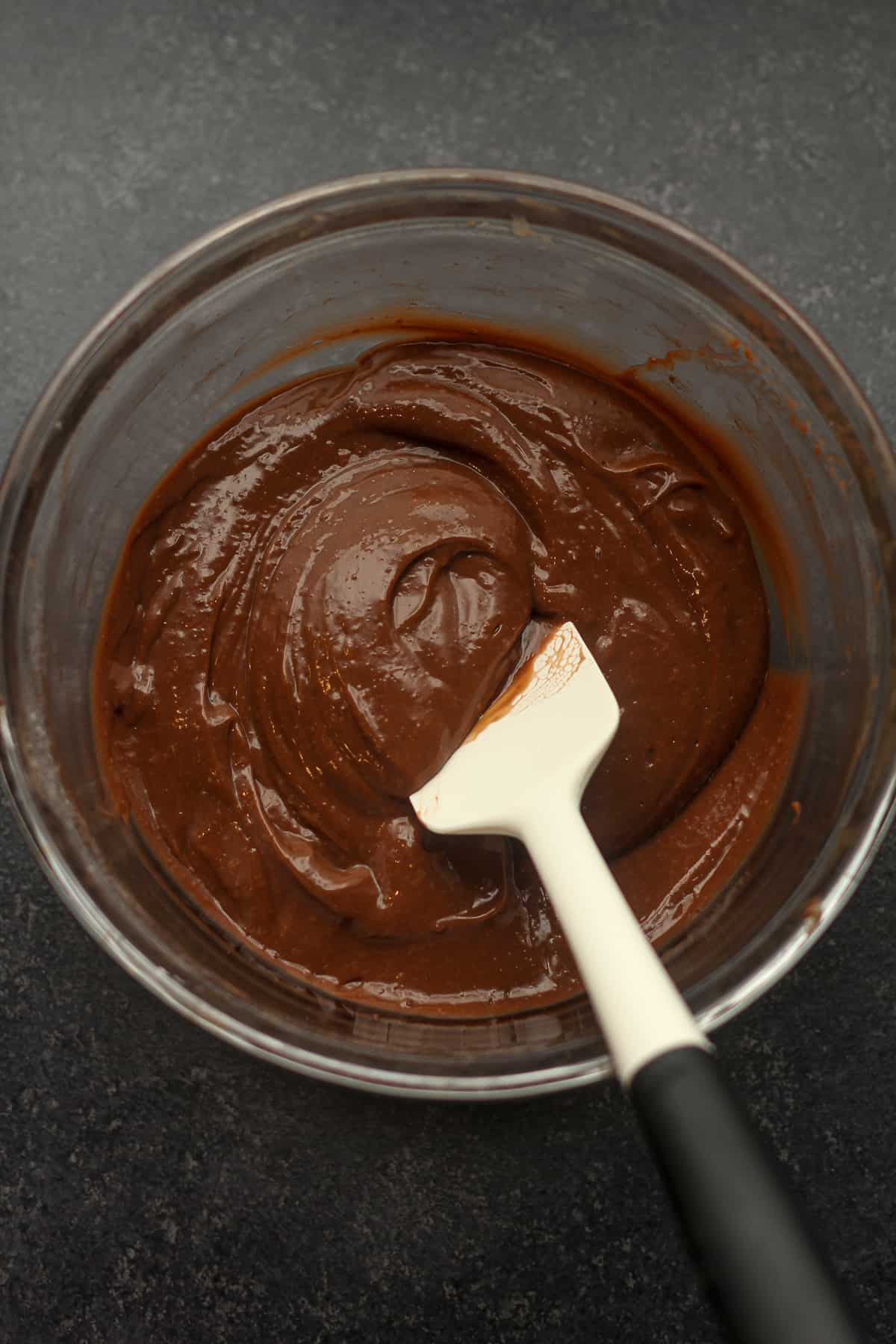 A bowl of the chocolate pudding with a white spatula.
