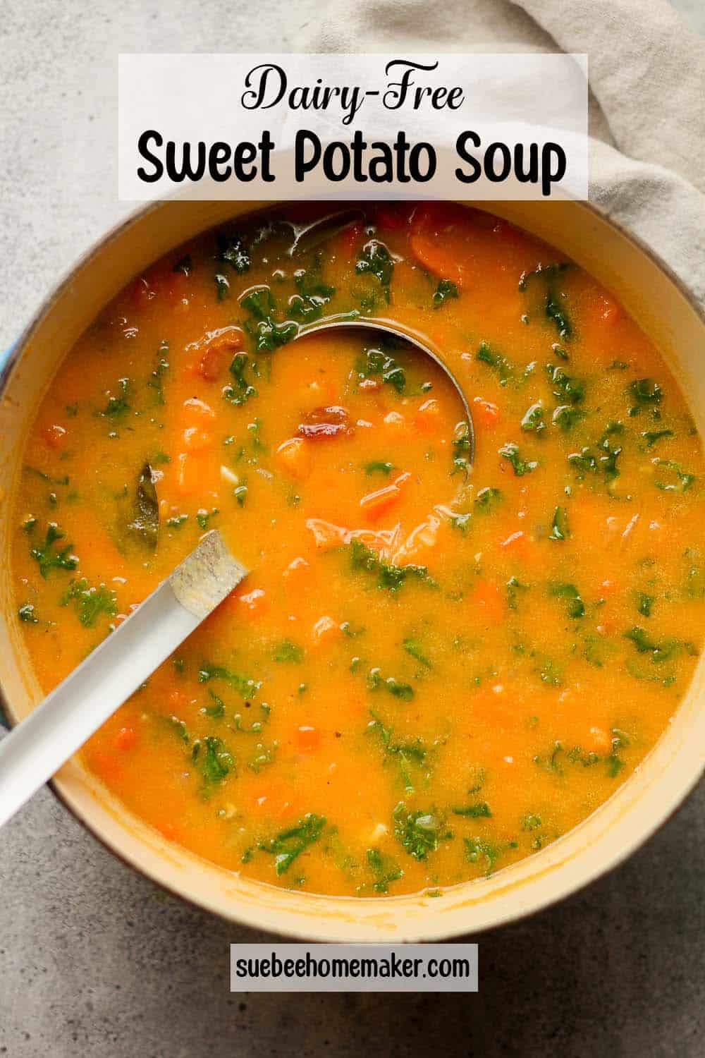 A large pot of Dairy-Free Sweet Potato Soup with a soup ladle inside.