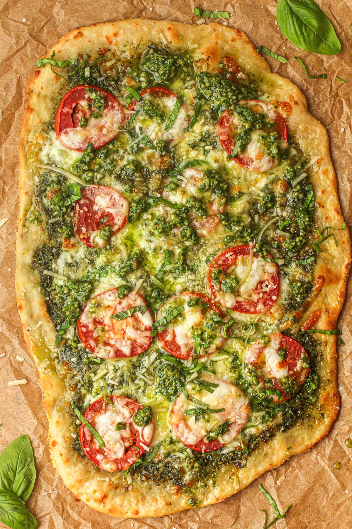 An oval shaped pesto flatbread pizza.