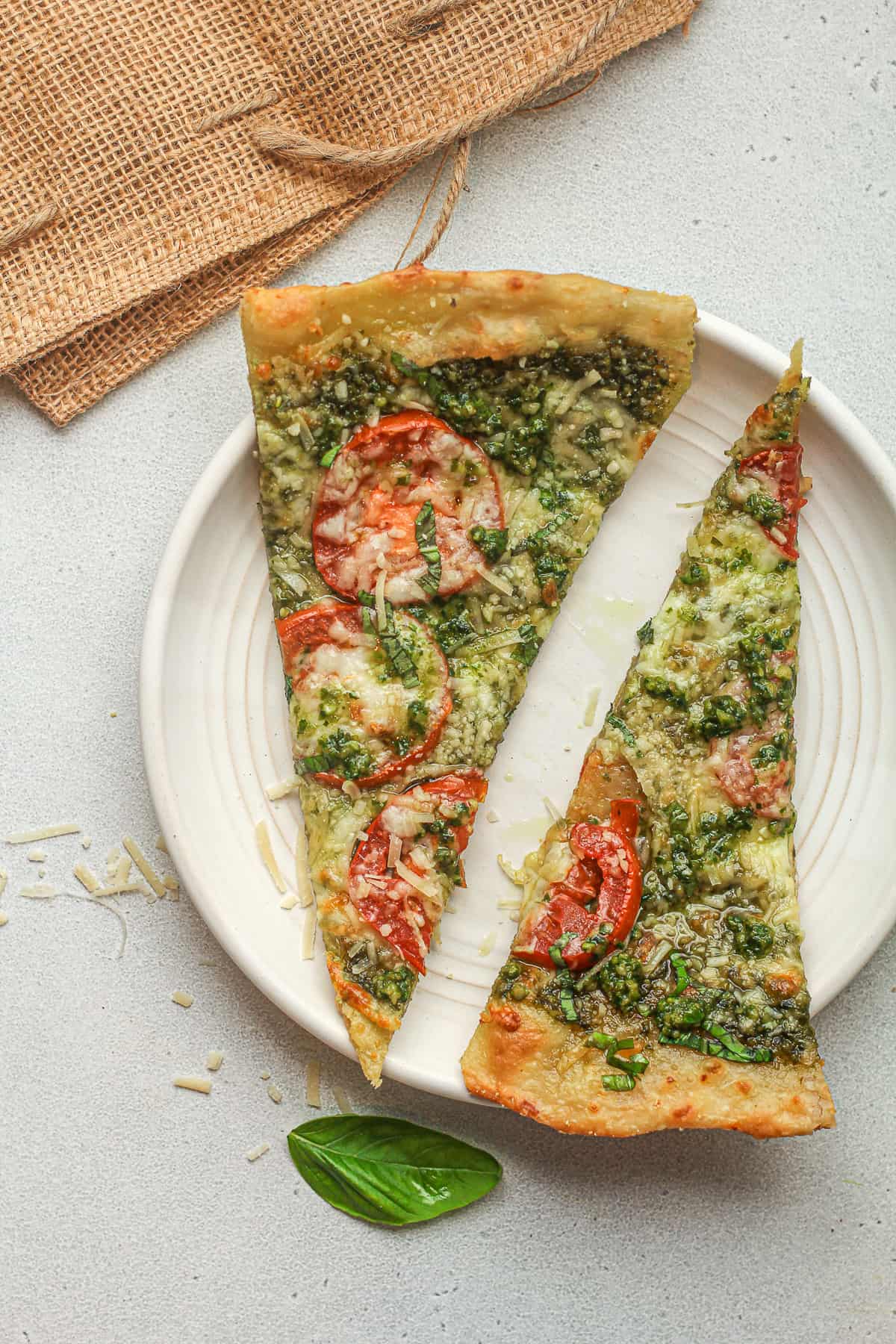 A plate of two wedges of pesto flatbread pizza.
