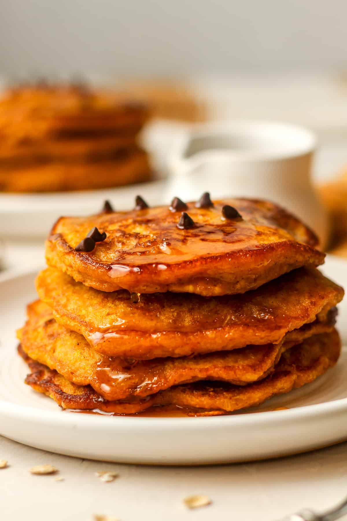 Side closeup via of four stacked pumpkin oatmeal pancakes.