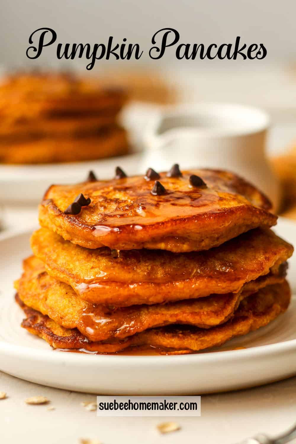 Side view of a plate of four stacked pumpkin pancakes.
