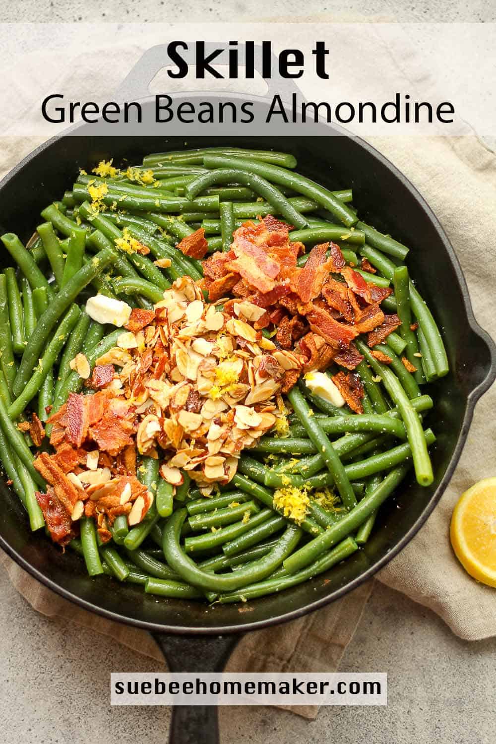 A skillet of blanched green beans with crispy bacon and toasted almonds on top.