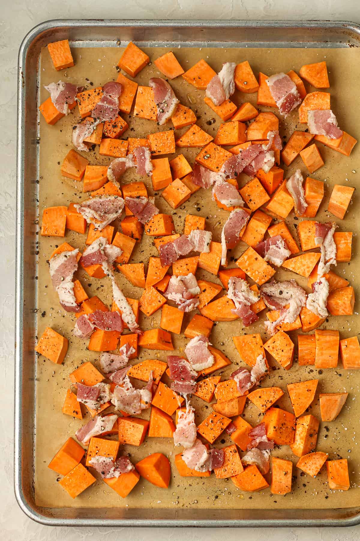 Chopped sweet potatoes with bacon before roasting.